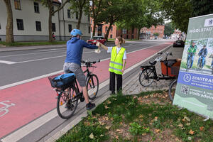 Bild vergr&ouml;&szlig;ern: Bei der Sommerradl-Aktion verteilt die Fahrradbeauftragte der Stadt Ingolstadt, Theresa Schneider, Geschenke an die Radfahrer